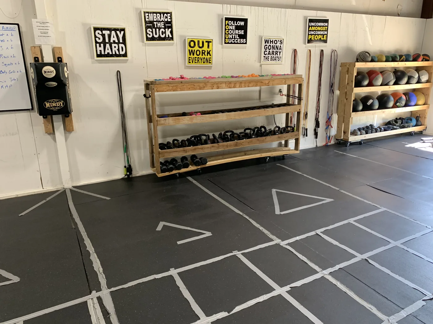 Kettlebells, dumbbells, medicine balls, and jump ropes on the equipment racks