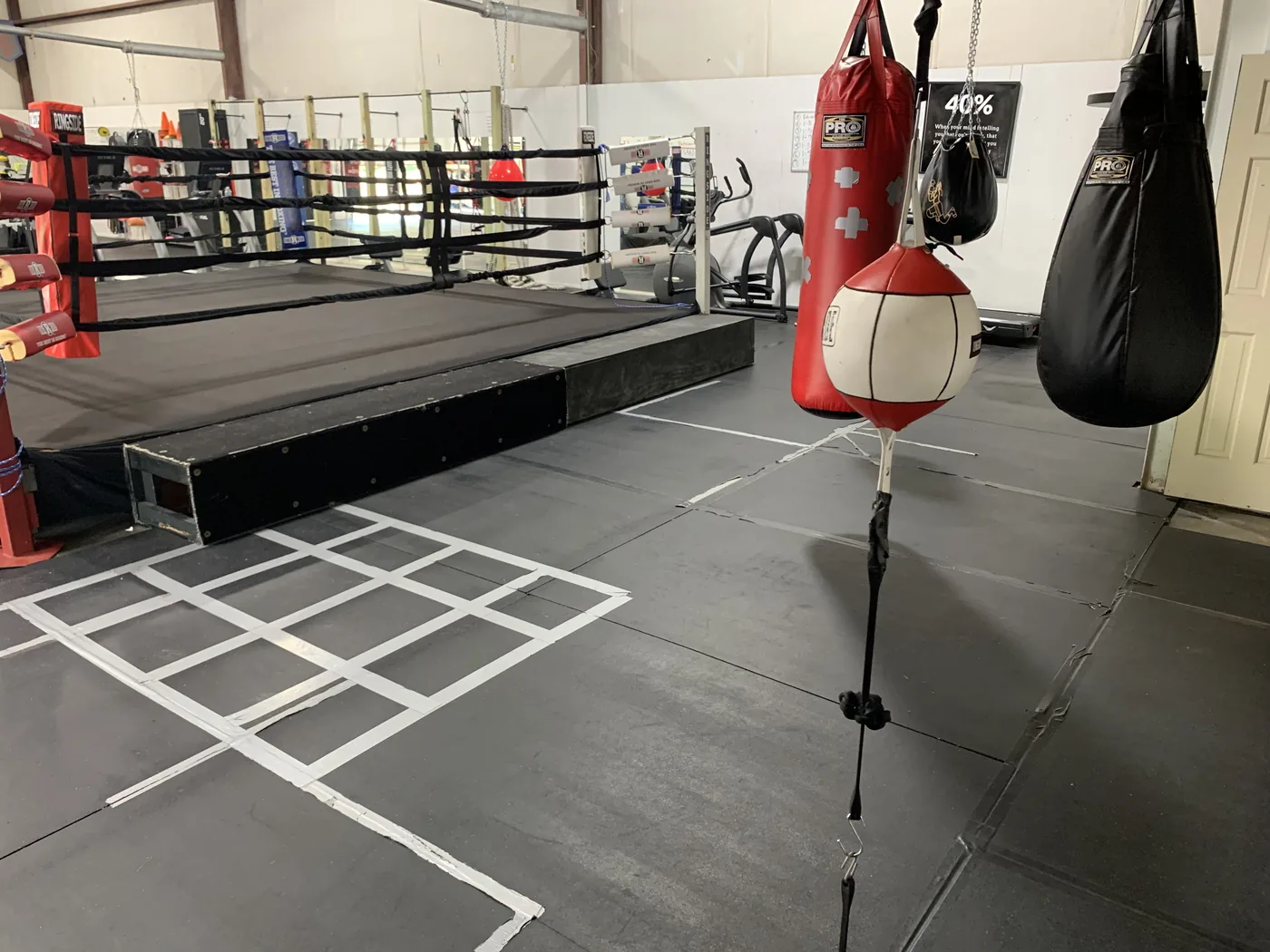 The boxing ring corner alongside heavy bags and a speed bag